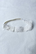 Bandeau cheveux bébé fille en dentelle blanc cassé avec nœud sur le côté. A porter pour un baptême ou une cérémonie. Boutique Fil de Légende à Paris, Neuilly-sur-Seine.