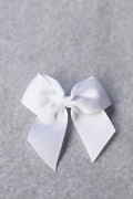 Pince cheveux noeud en gros grain blanc pour petite fille. Parfait pour sublimer une robe de cérémonie pour enfant. Boutique Fil de Légende à Paris, Neuilly-sur-Seine.