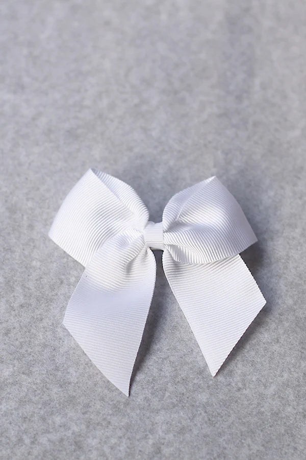 Pince cheveux noeud en gros grain blanc pour petite fille. Parfait pour sublimer une robe de cérémonie pour enfant. Boutique Fil de Légende à Paris, Neuilly-sur-Seine.