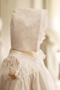 Bonnet de baptême bébé fille Amaia en dentelle italienne doublé coton. Création française Fil de Légende. Disponible en ligne et à la boutique Fil de Légende à Paris, Neuilly-sur-Seine.