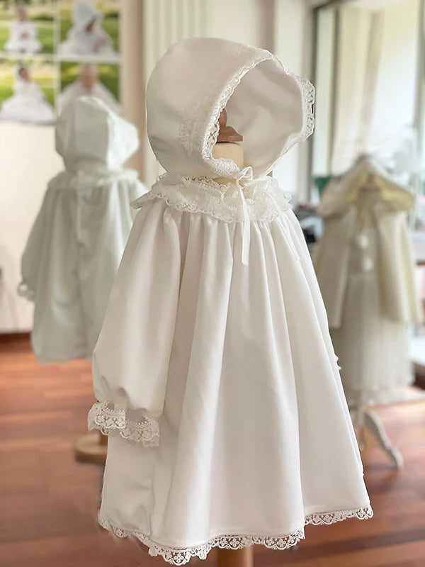 Bonnet baptême bébé fille pour l'hiver en velours blanc cassé et dentelle. Doublure polaire. Création française Fil de Légende. Photo du bonnet porté avec la robe assortie.