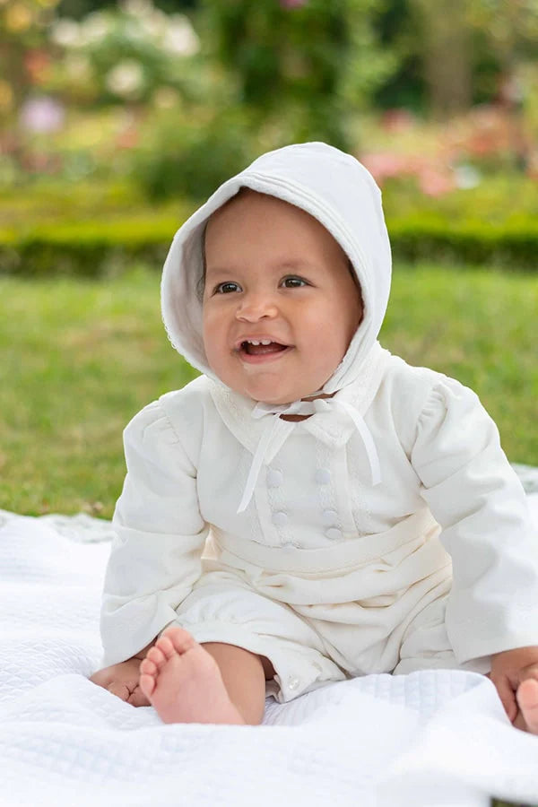 Bonnet baptême bébé garçon Paul pour l'hiver en velours de coton blanc cassé et galon de dentelle de coton. Création française Fil de Légende. Photo du bonnet porté par un bébé garçon vu de près.