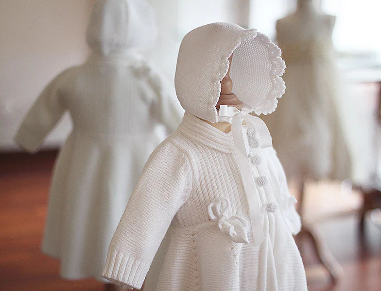 Bonnet de baptême Pauline tricoté en laine mélangée blanc cassé. Bordures de bonnet faites au crochet à la main. Création française Fil de Légende. Photo du bonnet vu de coté.