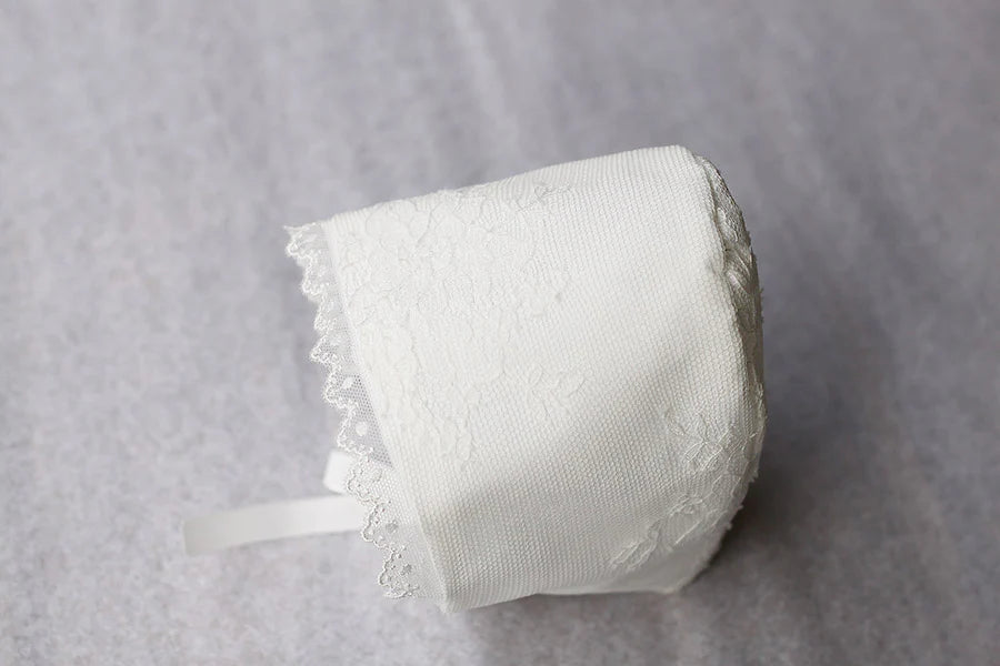 Bonnet de baptême traditionnel pour bébé en dentelle fine. Couleur blanc cassé. Fait main en France. Vue du dessus.