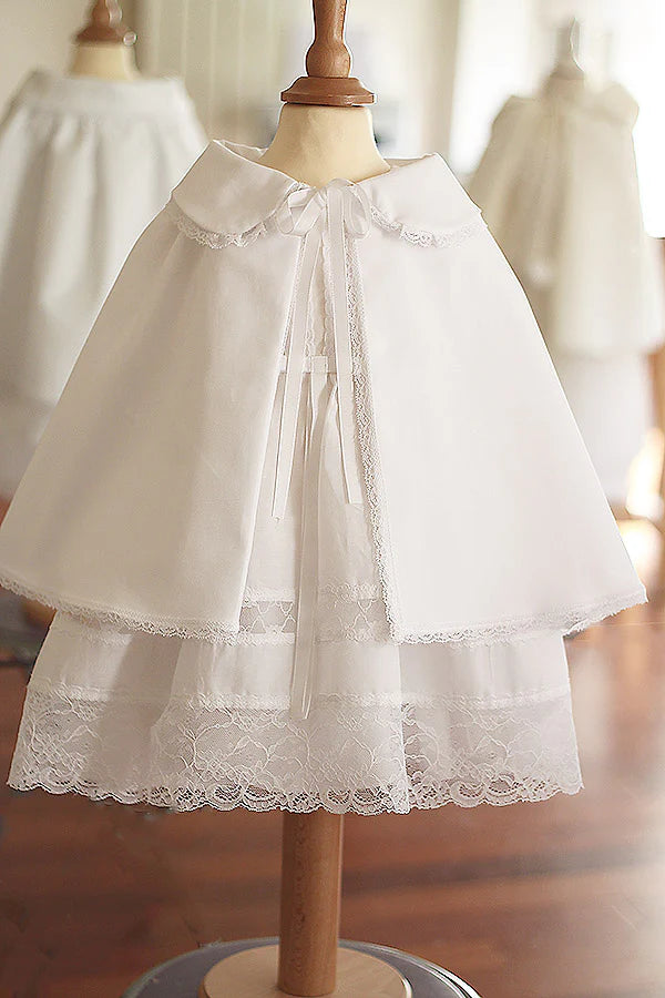 Cape de baptême bébé fille en coton blanc et galon de dentelle. Création française Fil de Légende. Disponible en ligne ou en boutique showroom à Paris, Neuilly-sur-Seine.