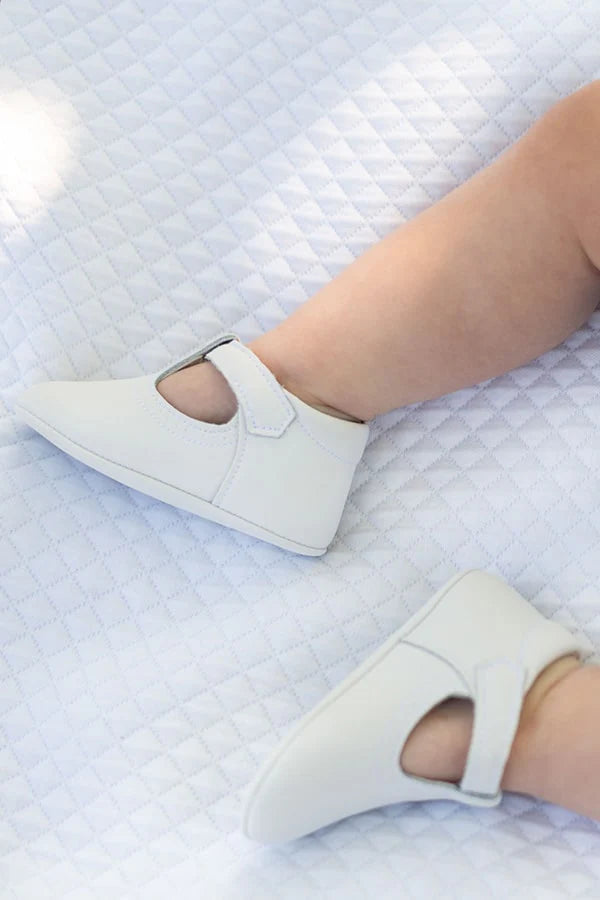 Chaussons baptême cérémonie bébé fille ou garçon pour l'été. Chaussons en cuir blanc avec une ouverture à boucle. Vue de près