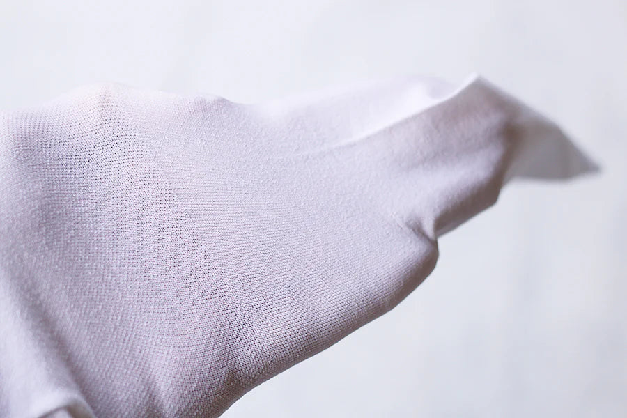 Collant fin blanc pour bébé fille, de type collant de danse. Idéal à porter avec une robe de cérémonie. Photo de la texture du collant.