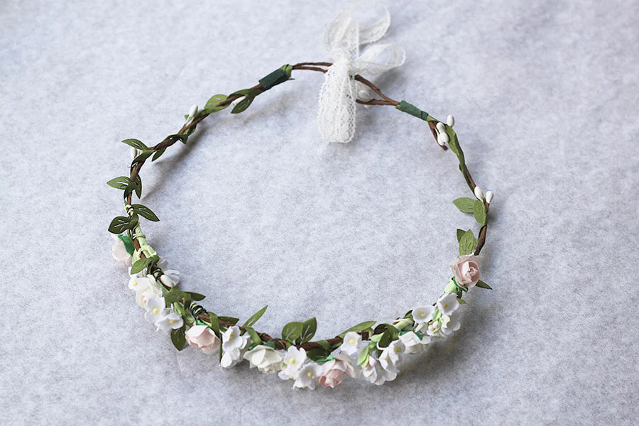 Couronne de fleurs artificielles blanche et rose pâle pour petites filles à porter pour accessoiriser une robe de cérémonie pour enfant et sublimer une coiffure.