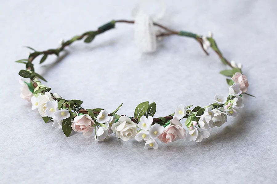 Couronne de fleurs artificielles blanche et rose pâle pour petites filles à porter pour accessoiriser une robe de cérémonie pour enfant et sublimer une coiffure.