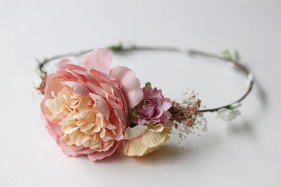 Couronne de fleurs artificielles avec fleurs roses et jaune pâle à porter avec une robe de cérémonie pour enfants. Parfait pour sublimer une coiffure de petite fille. Photo du gros plan des fleurs de la couronne.