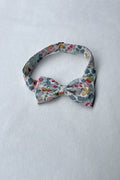 Nœud papillon pour petit garçon en coton Liberty avec fleurs de couleurs bleu gris, rouge et rose. idéal à porter pour un cortège de mariage. Boutique Fil de Légende Paris, Neuilly-sur-Seine.