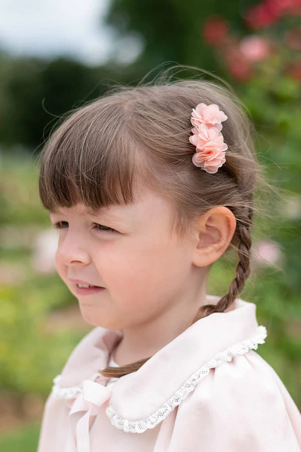 Pince cheveux fille avec trois fleurs en tissu rose. Parfait pour sublimer la coiffure d'une petite fille à l'occasion d'une cérémonie.