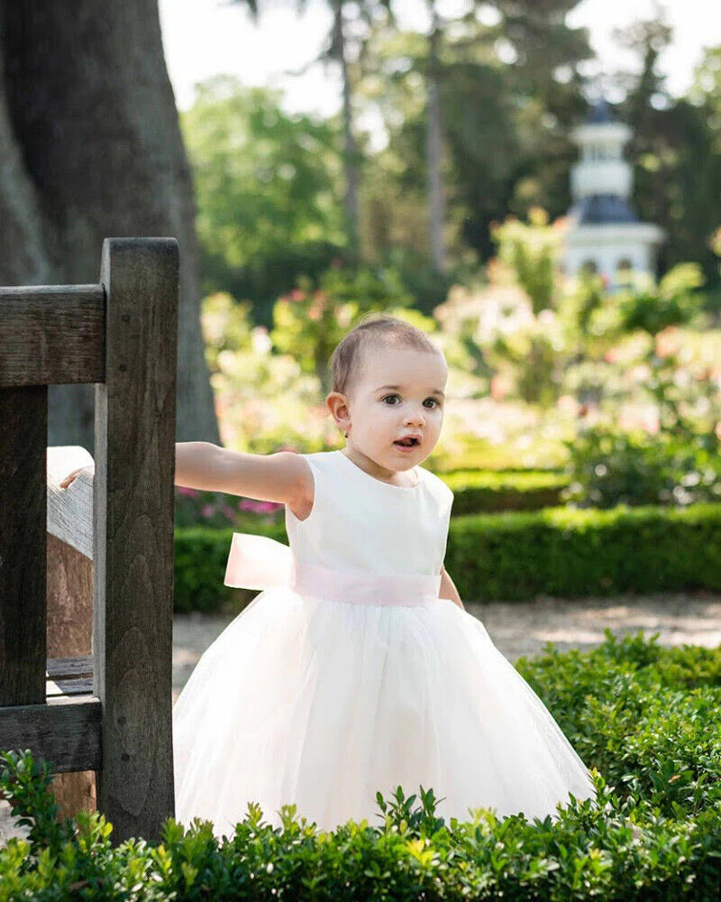 Robe de baptême ou de cérémonie pour bébé fille en coton blanc cassé avec une jupe en tulle et une ceinture rose poudré. Photo du corsage.