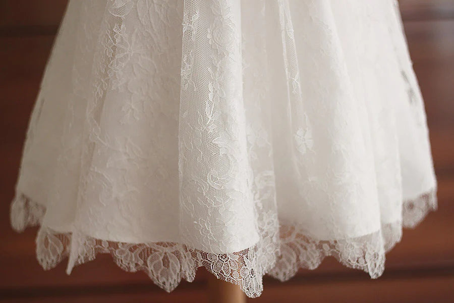 Robe de baptême fille en dentelle fine avec manches, corsage et jupe en dentelle. Cousu main en France. Photo de la dentelle de la jupe.