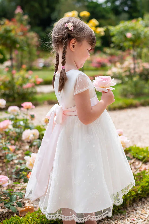 Robe de baptême ou de cérémonie pour bébé et petite fille en dentelle de Calais, doublée de satin, modèle été à manches courtes. Création Fil de Légende. Photo de robe portée par une petite fille.