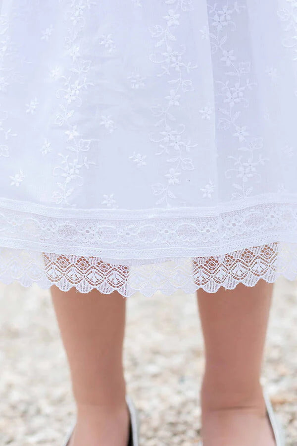 Robe de baptême et de cérémonie pour bébé fille, en broderie anglaise blanche et dentelle de Calais. Robe de baptême haut de gamme, création française Fil de Légende. Photo de la dentelle de la jupe.