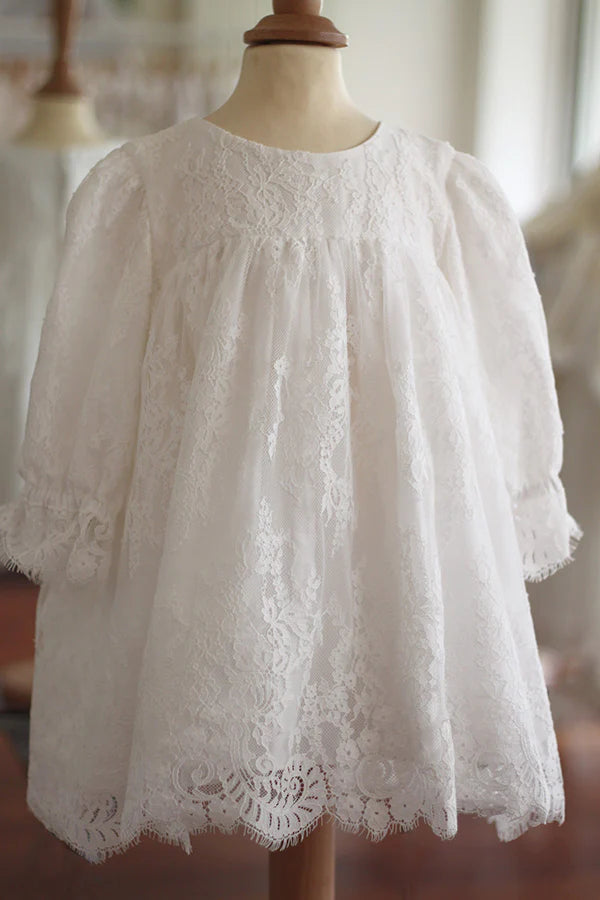 Robe de baptême fille taille haute en dentelle italienne blanc cassé doublée polaire. Modèle chaud hiver avec manches longues. Création française Fil de Légende. Disponible en ligne et en boutique showroom à Paris, Neuilly-sur-Seine.