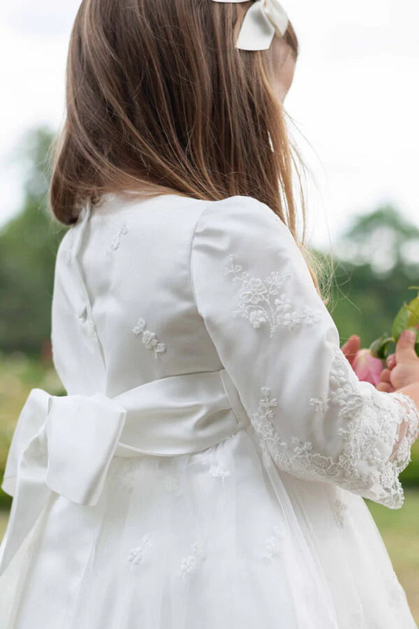 Robe de baptême et de cérémonie pour bébé et petite fille, en tulle brodé blanc cassé doublé de satin. Robe automne-hiver manches longues. Création française Fil de Légende. Photo des motifs de dentelle.