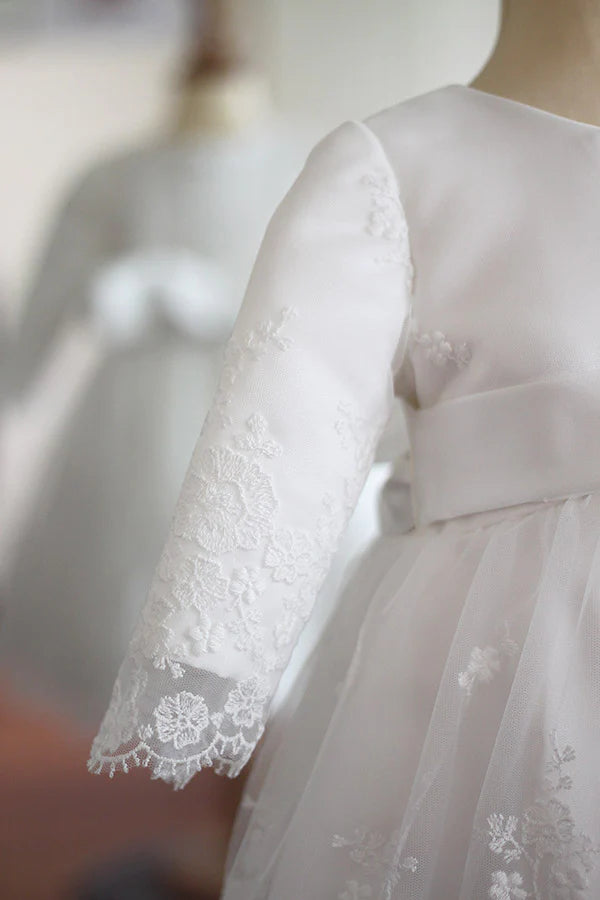 Robe de baptême et de cérémonie pour bébé et petite fille, en tulle brodé blanc cassé doublé de satin. Robe automne-hiver manches longues. Création française Fil de Légende. Photo de la robe sur mannequin de couture.