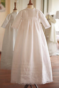Robe baptême traditionnelle mixte pour bébé fille ou garçon en coton blanc et dentelle de Calais. Modèle manches longues. Création française Fil de Légende. Disponible en ligne ou en boutique showroom à Paris, Neuilly-sur-Seine.