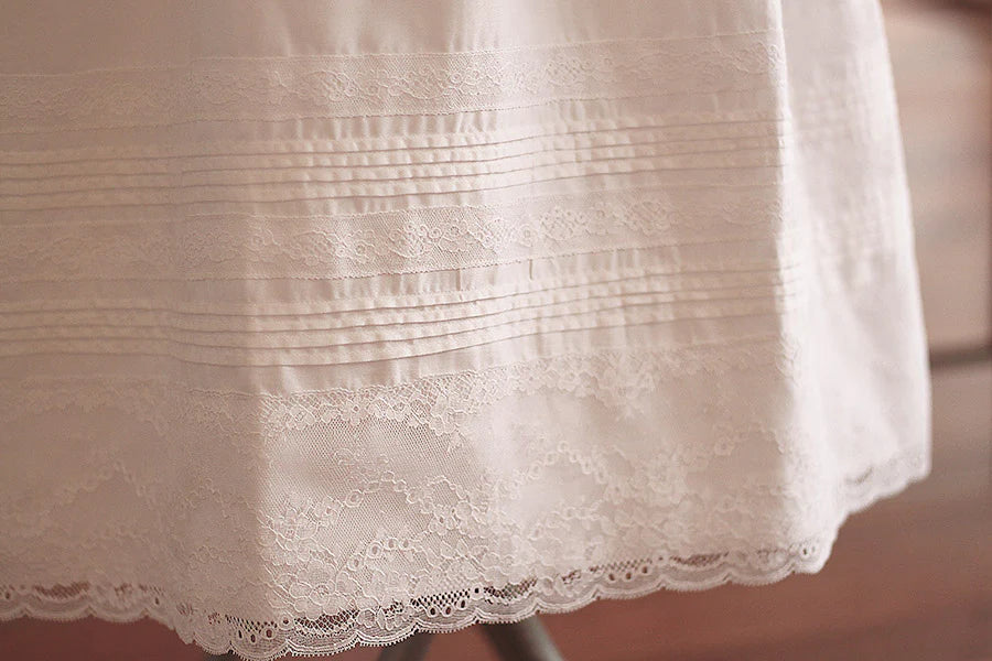 Robe baptême traditionnelle mixte pour bébé fille ou garçon en coton blanc et dentelle de Calais. Modèle manches longues. Création française Fil de Légende. Photo des détails de la jupe.
