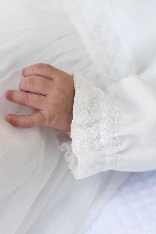 Robe de baptême longue traditionnelle mixte pour filles et garçons en mousseline et dentelle fine. Modèle manches longues. Création française Fil de Légende.  Photo des détails sur les manches.