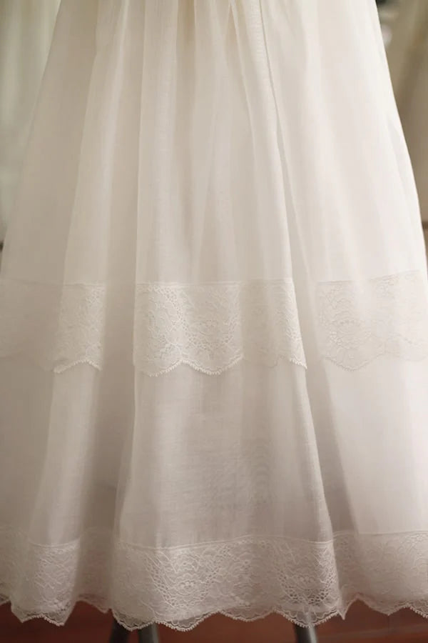 Robe de baptême longue traditionnelle mixte pour filles et garçons en mousseline et dentelle fine. Modèle manches longues. Création française Fil de Légende.  Photo de la jupe.