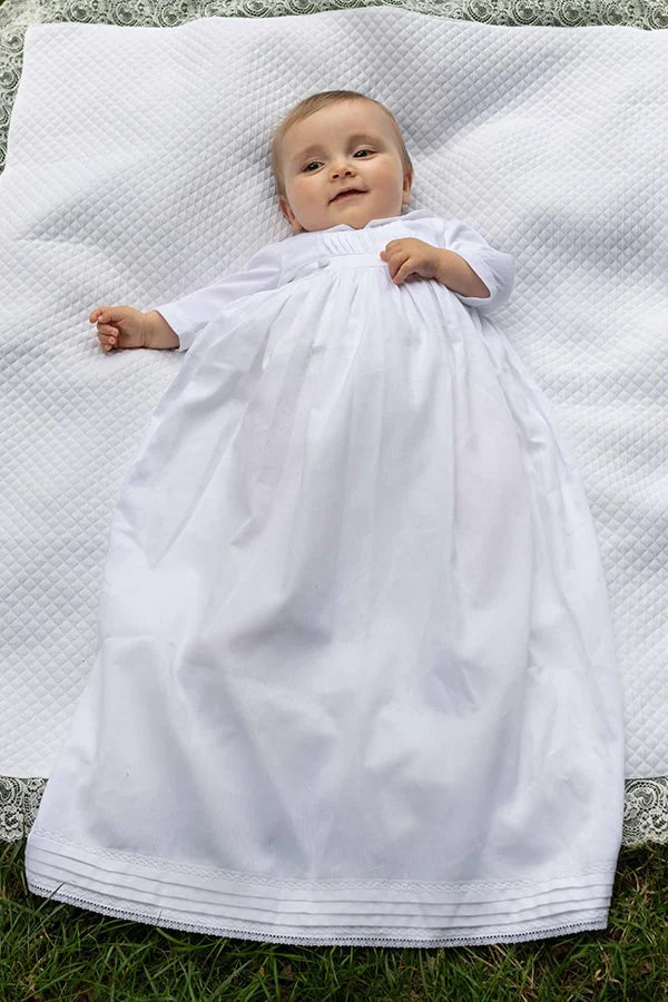 Robe de baptême traditionnelle bébé garçon Gabriel en piqué de coton blanc et dentelle de coton. Création française Fil de Légende. Photo de la robe portée par un bébé garçon.