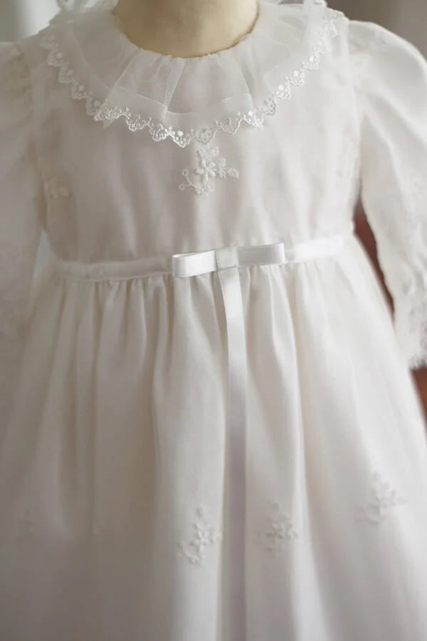 Robe de baptême traditionnelle bébé fille en tulle souple brodé et dentelle doublée coton. Création française Fil de Légende. Photo du noeud en satin.