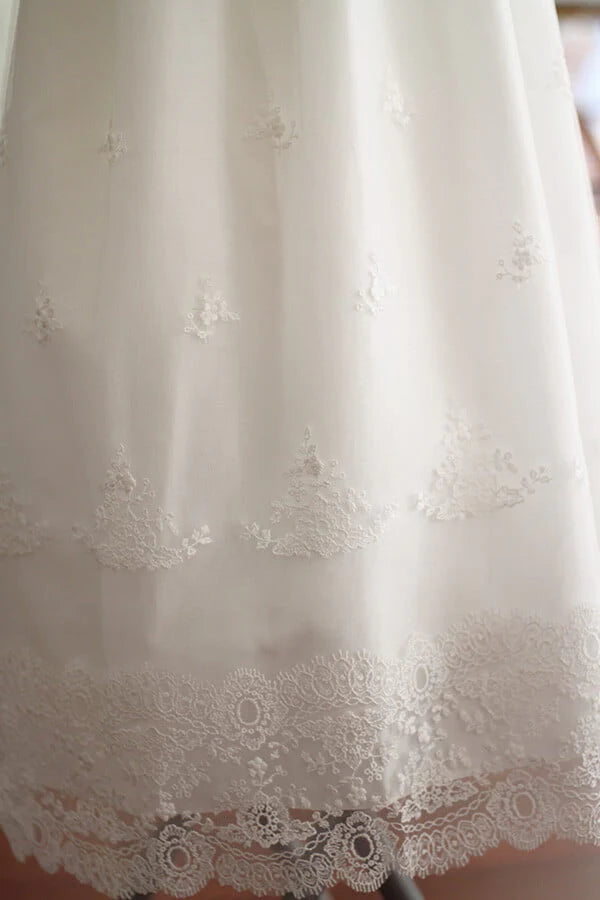 Robe de baptême traditionnelle bébé fille en tulle souple brodé italien et dentelle doublée coton. Modèle manches longues. Création française Fil de Légende.  Photo des motifs de la jupe.
